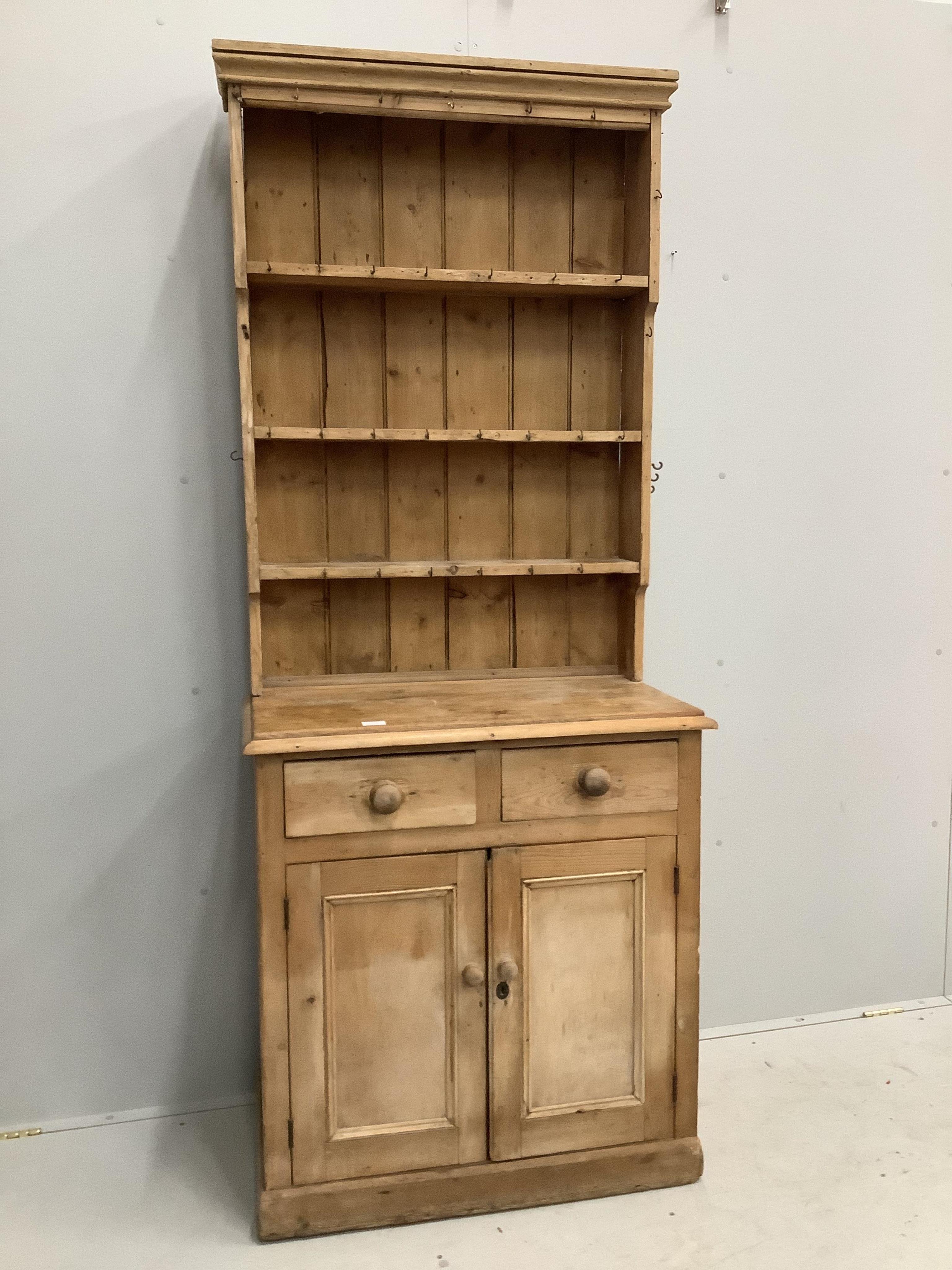 A narrow Victorian style pine dresser with boarded rack, width 85cm, depth 48cm, height 210cm. Condition - fair